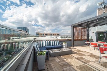 A rooftop patio with a blue couch and wooden deck at Regatta Sloans Lake Apartments, Colorado
